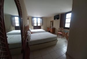 ein Schlafzimmer mit zwei Betten, einem Tisch und Stühlen in der Unterkunft Hotel Santander Veracruz in Veracruz