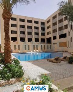 a hotel with a swimming pool in front of a building at CAMUS 443, Princess Resort in Hurghada