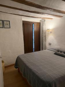 a bedroom with a blue bed in a room at El Encantodemora in Mora de Rubielos
