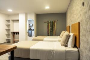 a hotel room with two beds and a kitchen at Hotel Bambu Milla De Oro in Medellín