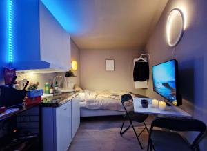 a small room with a bed and a desk with a computer at Cozy Central Studio by the Bus Station in Bergen