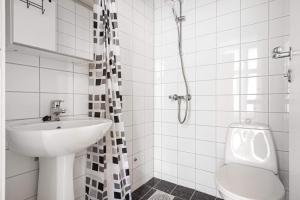 a white bathroom with a sink and a toilet at Cozy Central Studio by the Bus Station in Bergen