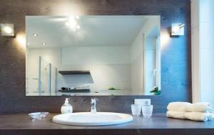 a bathroom with a sink and a large mirror at Tillmanns Stadtlounge in Norden +29 photos