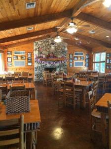 a restaurant with wooden tables and chairs and a stone wall at La Casita in Concan