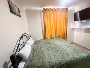 a small bedroom with a bed and a window at Crystal Luxury Palace in Nairobi