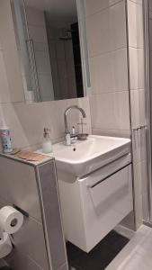 a white bathroom with a sink and a mirror at Lohbachhof in Wolfhagen