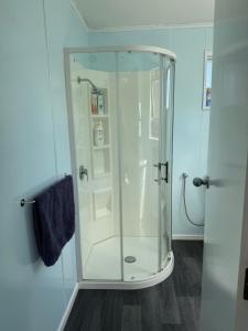 a shower with a glass enclosure in a bathroom at Delight On Dalton in Hokitika +10 photos