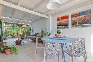 a dining room with a blue table and chairs at A CASA DA PRAIA DO FORTE in Praia do Forte