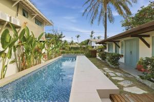 an image of a swimming pool next to a house at A CASA DA PRAIA DO FORTE in Praia do Forte