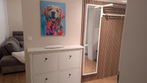 a mirror on a dresser with a painting of a dog at Lohbachhof in Wolfhagen