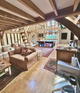 a living room with a couch and a table at Luxurious Country Barn in Baughurst