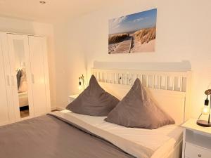a bedroom with a bed with two pillows at Ferienhaus Teenös in Hinte