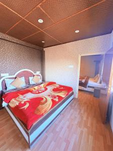 a bedroom with a large bed with a red blanket at Nature Nook's Kufri in Kūfrī