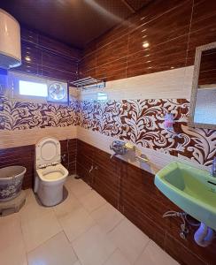a bathroom with a toilet and a sink at Nature Nook's Kufri in Kūfrī