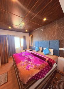a bedroom with a large bed with a purple blanket at Nature Nook's Kufri in Kūfrī