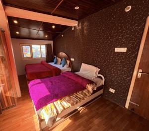 a bedroom with two beds in a room with a wall at Nature Nook's Kufri in Kūfrī
