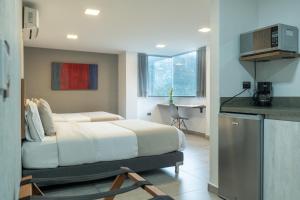 a hotel room with a bed and a kitchen at Hotel Bambu Milla De Oro in Medellín