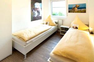 a bedroom with two beds and a window at Tillmanns Stadtlounge in Norden