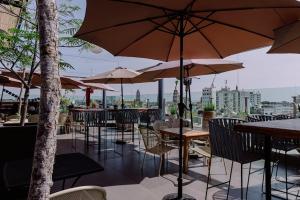 a restaurant with tables and chairs and umbrellas at Kasa Hotel & Suites in Irapuato