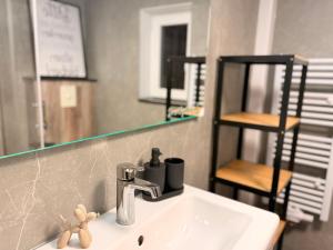 a bathroom sink with a faucet and a mirror at Ferienhaus Teenös in Hinte +15 photos