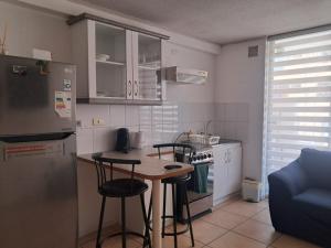 a kitchen with a table and chairs and a refrigerator at Moderno Depto 1D con Estacionamiento Gratis Ideal Trabajo in Antofagasta