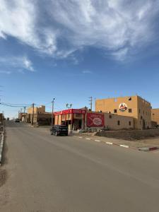 an empty street with a car parked on the side of the road at Maison La Baraka Merzouga in Merzouga