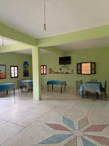 a room with tables and a tv on the wall at Maison La Baraka Merzouga in Merzouga