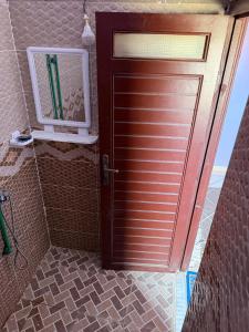 a door in a bathroom with a mirror next to it at Maison La Baraka Merzouga in Merzouga +36 photos