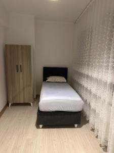 a small bedroom with a bed and a cabinet at Roz Family Mansion 2 in Diyarbakır