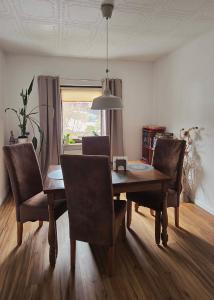 a dining room with a wooden table and chairs at Ferienwohnung Schneeberg in Schneeberg
