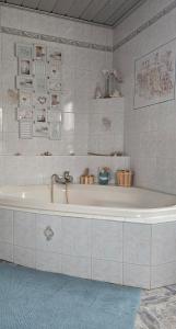 a white bath tub in a bathroom with tiles at Ferienwohnung Schneeberg in Schneeberg