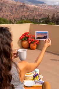 a woman taking a picture of a table with flowers at Tala Huasi in Tilcara