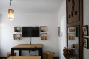 a living room with a table and a tv on a wall at KOKIRA Apê in Campinas