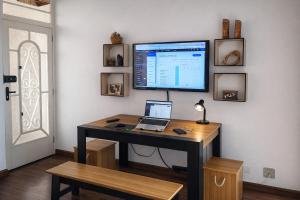 a desk with a computer monitor and a laptop on it at KOKIRA Apê in Campinas