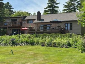 a house with a deck and an umbrella in a yard at Bayfield Island View Lodging, Bayfield, WI in Bayfield