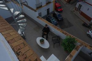 a man sitting at a table in a building at Charming Apartment with Private Terrace in Sanlúcar de Barrameda +47 photos