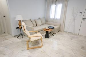 a living room with a couch and a chair and a table at Charming Apartment with Private Terrace in Sanlúcar de Barrameda