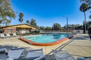a large swimming pool with chairs and a building at Sun, Sand & Poolside Relaxation! Ormond Beach Unit in Ormond Beach