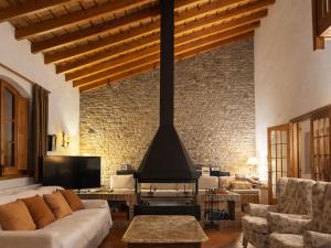 a living room with a couch and a fireplace at Masia Can Cenç in Collsuspina