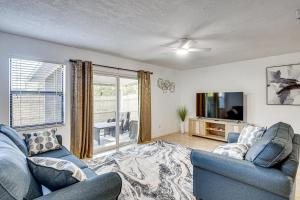 a living room with a blue couch and a tv at Sun, Sand & Poolside Relaxation! Ormond Beach Unit in Ormond Beach
