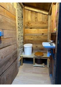 a wooden bathroom with a sink and a toilet at Maison de Vignes de Tournemire in Tournemire