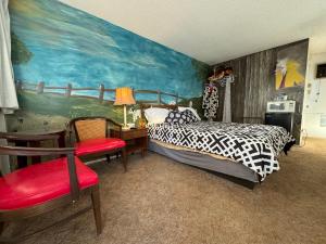 a bedroom with a bed and a painting on the wall at Stagecoach 66 Motel by Capital O in Seligman +35 photos