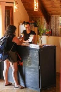 a man and a woman standing at a counter at Bungalow Hostel Iguazú in Puerto Iguazú