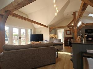 a living room with a couch and a tv at 1 Bed in Langmere oc-m33974 in Dickleburgh