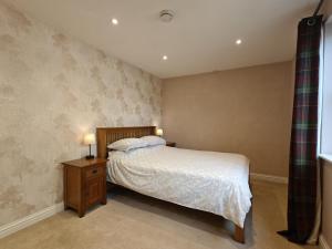 a bedroom with a bed and a nightstand with two lamps at 1 Bed in Langmere oc-m33974 in Dickleburgh