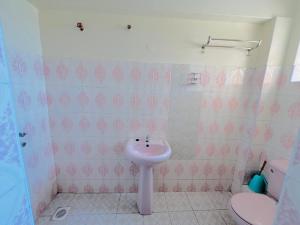 a bathroom with a pink sink and a toilet at Crystal Luxury Palace in Nairobi +9 photos