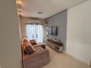a living room with a couch and a television at Casa com piscinas paragominas in Paragominas