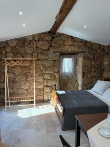 a bedroom with a stone wall with a bed in it at Bergerie du Riccio avec piscine privée in Cauro