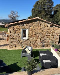 a stone house with two chairs and a table at Bergerie du Riccio avec piscine privée in Cauro