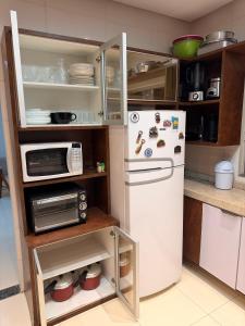 a kitchen with a refrigerator and a microwave at Casa com piscinas paragominas in Paragominas